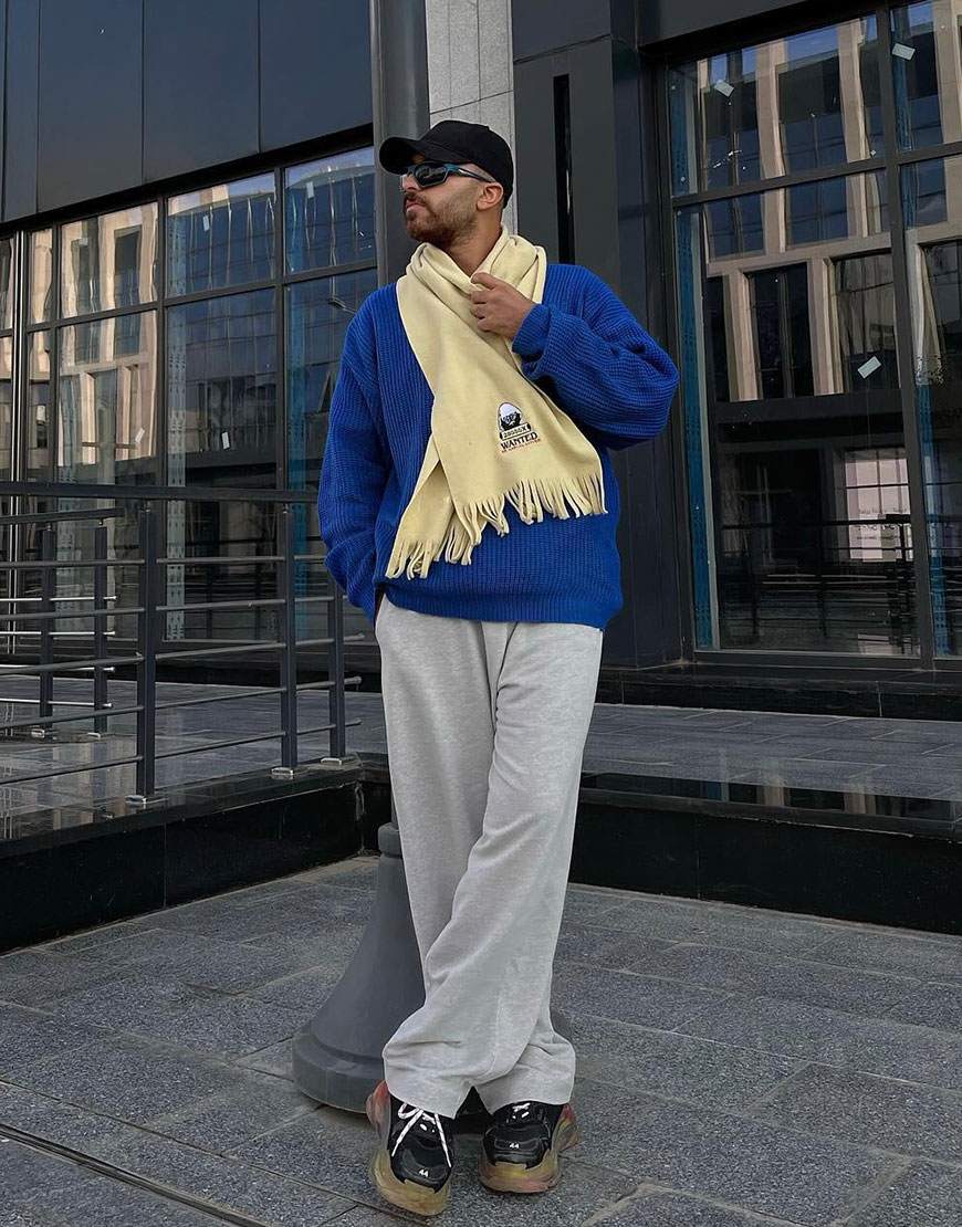 Man wearing blue jumper and yellow scarf
