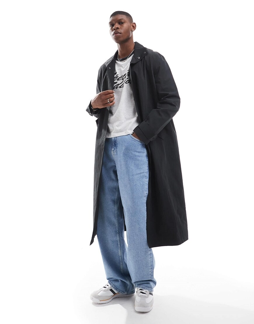 Model wearing black long trench coat and jeans