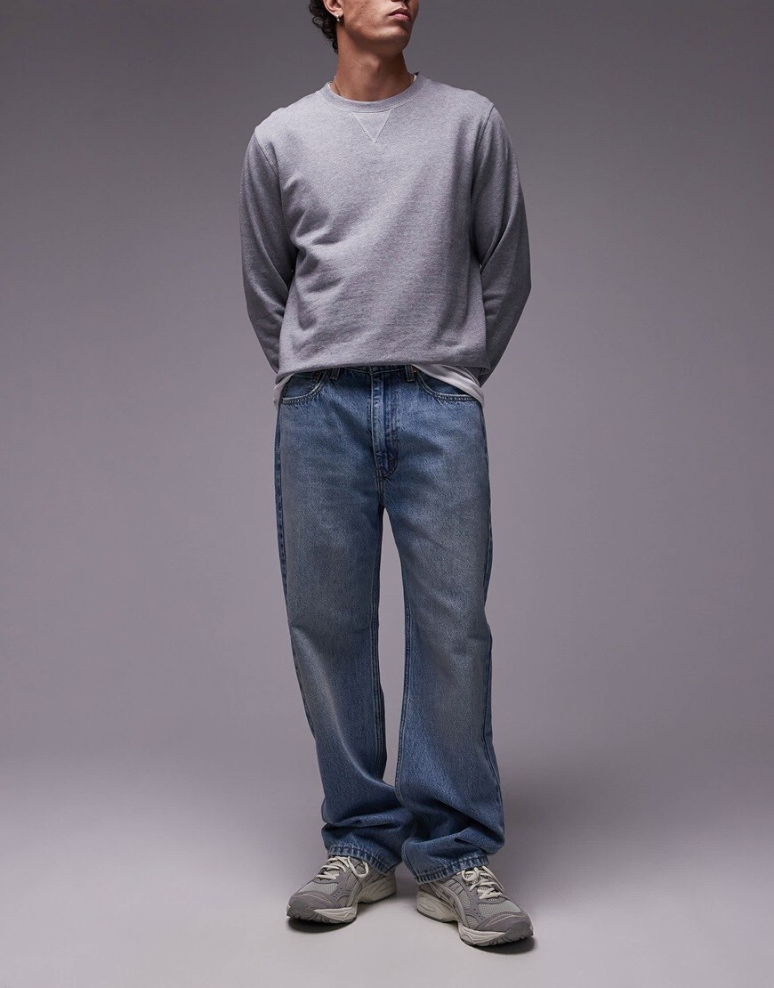 Model wearing grey jumper and jeans