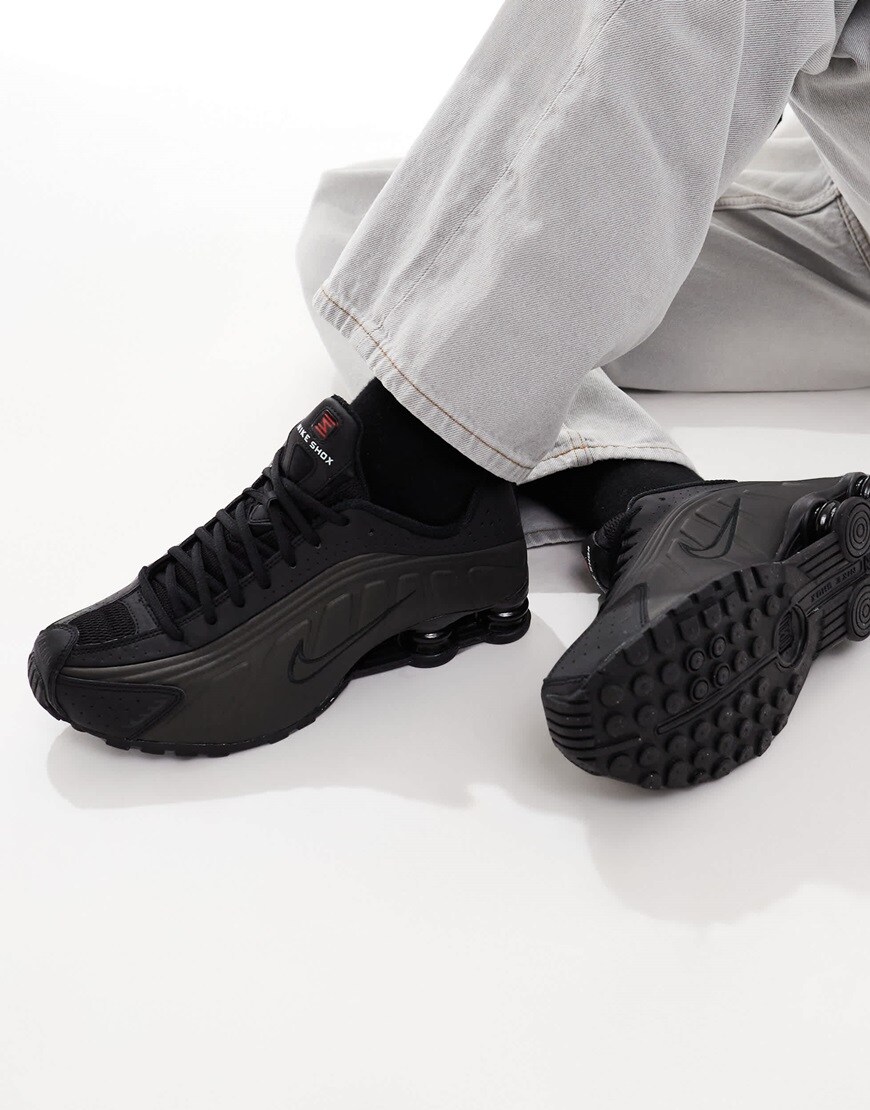 A model wearing black Nike trainers