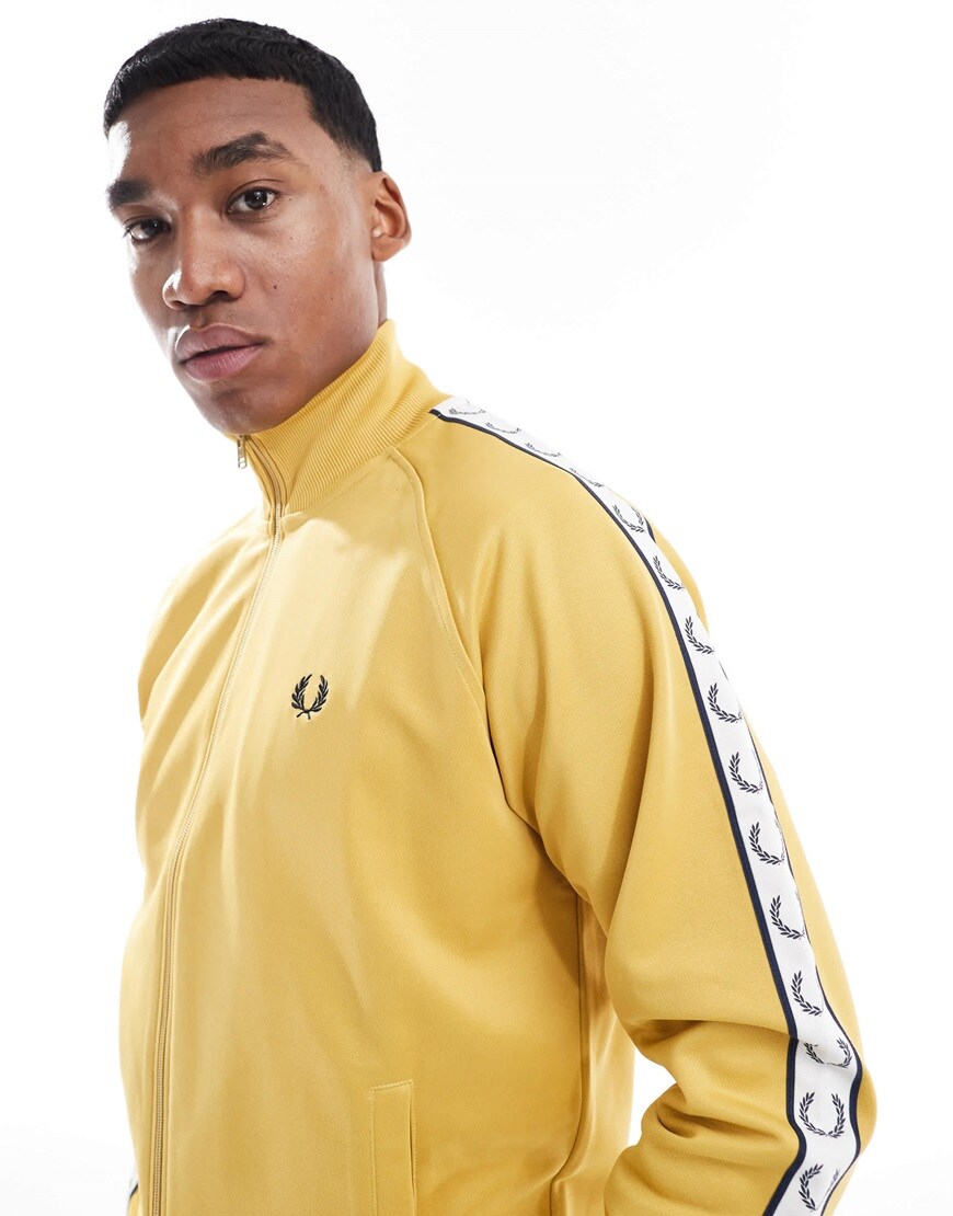 A model wearing a Fred Perry yellow track jacket