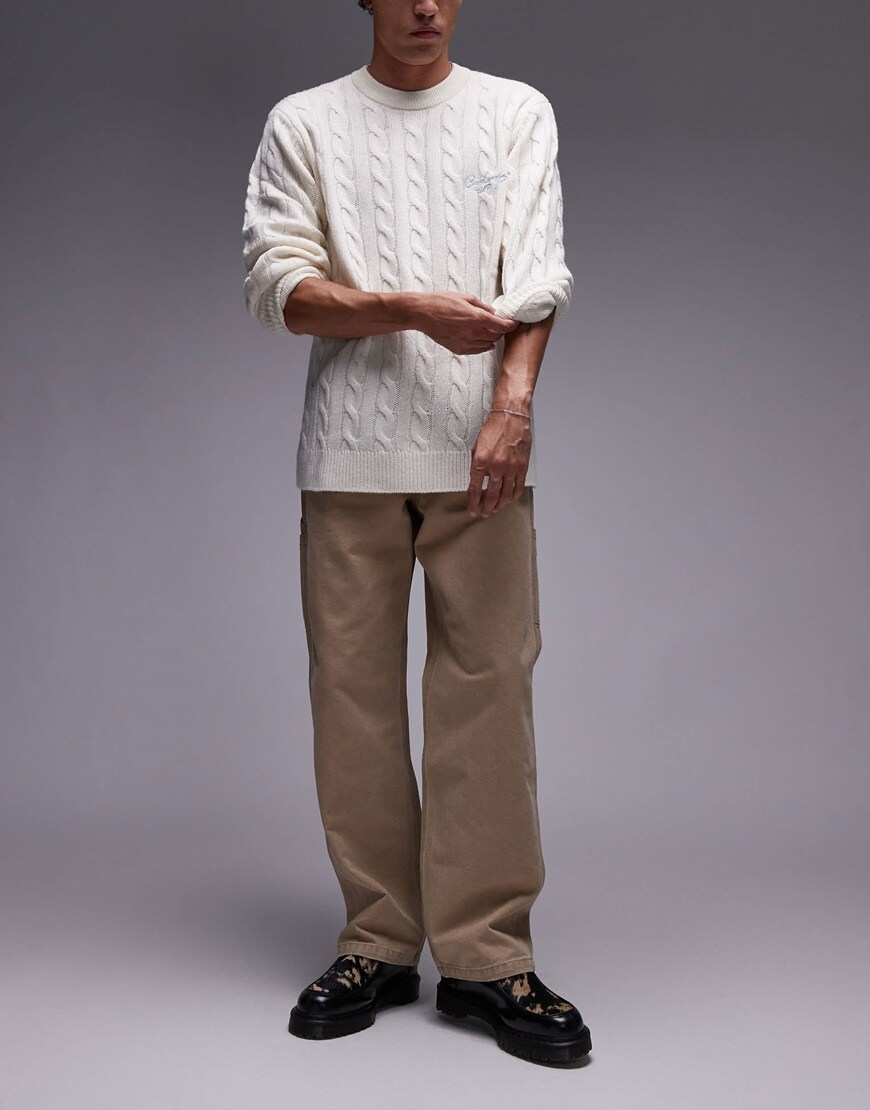 Model wearing brown chinos with white jumper