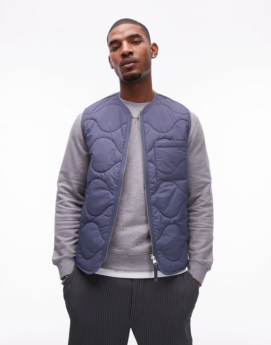 Model wearing blue puffer gilet