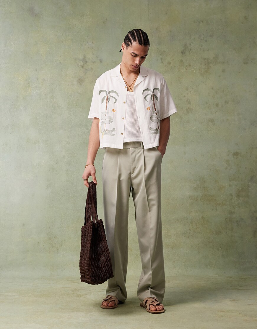 Man wearing a white shirt and green trousers