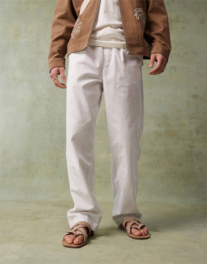 Man wearing white trousers and sandals