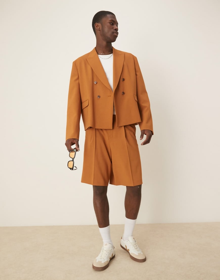 Model wearing a tan orange suit with suit shorts