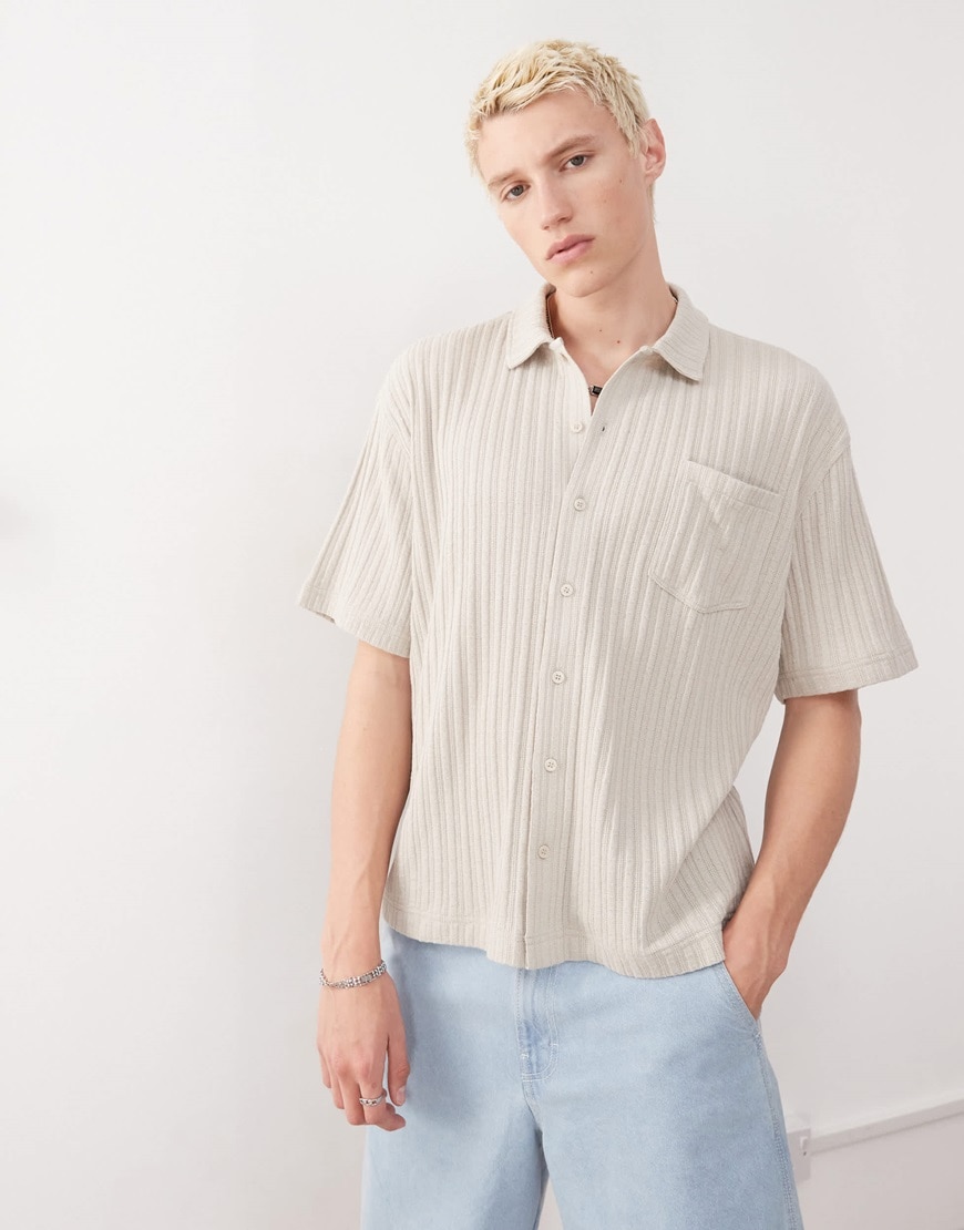A model wearing a ribbed beige shirt