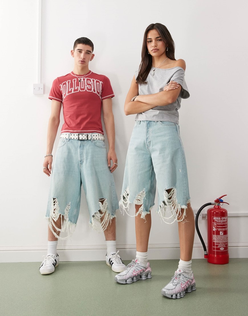 Two models wearing heavily distressed jorts