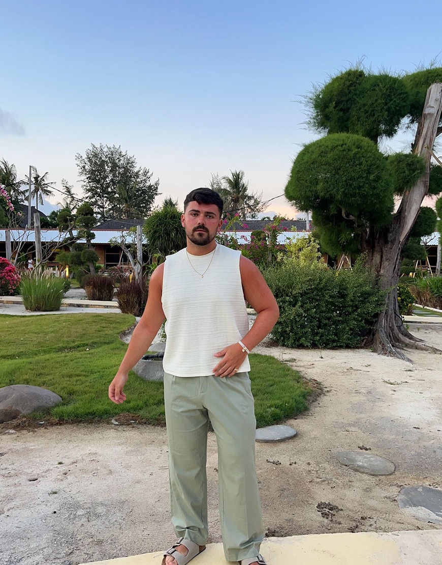 Man wearing a white shirt and green trousers