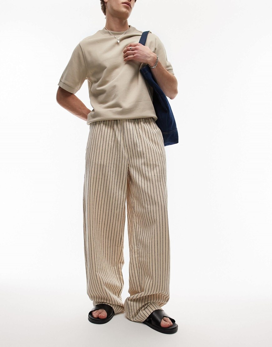 A model wearing baggy striped trousers in cream