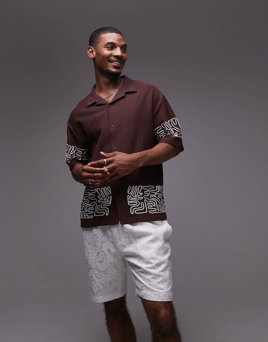 A model wearing a brown embroidered shirt