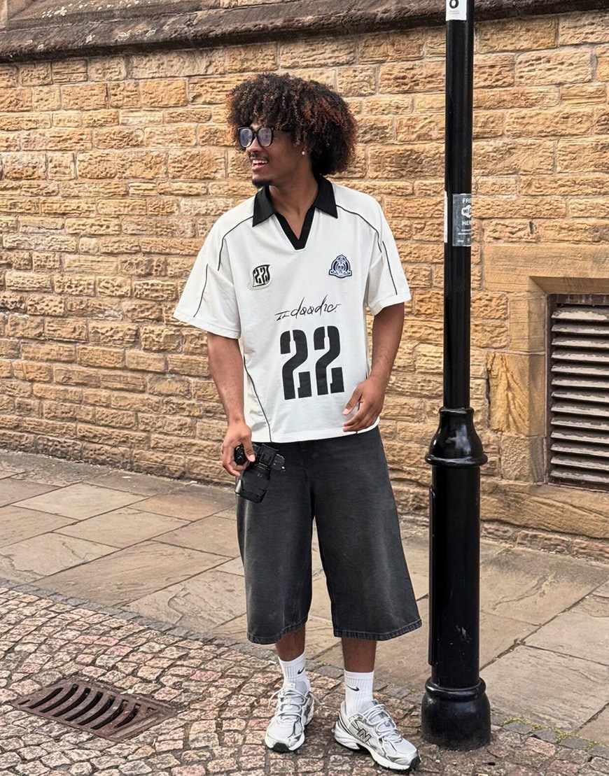 Man wearing black and white football jersey and jorts | ASOS Style Feed