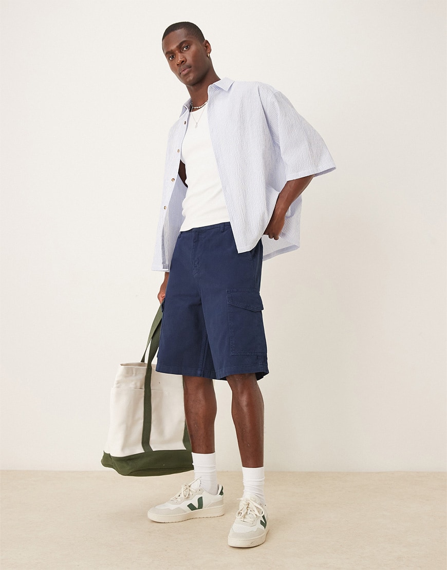 Model wearing long-line cargo shorts outfit