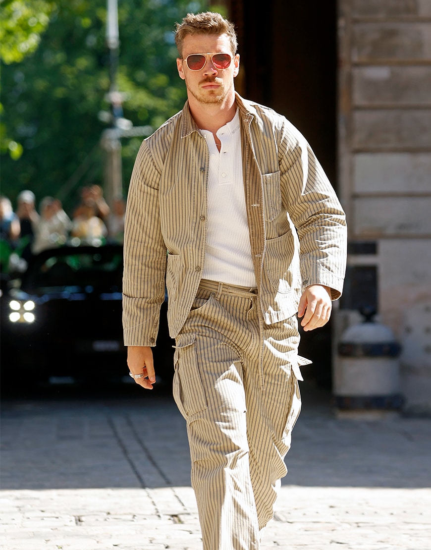 Will Poulter wearing a striped co-ord set and aviator sunglasses