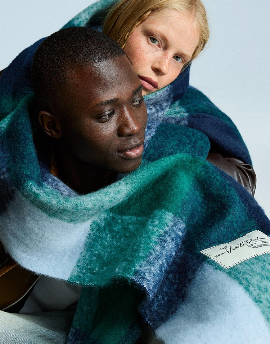 Man and woman wearing a green check scarf