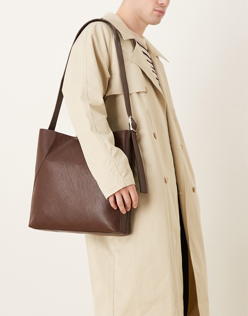 Man holding a brown crossbody bag