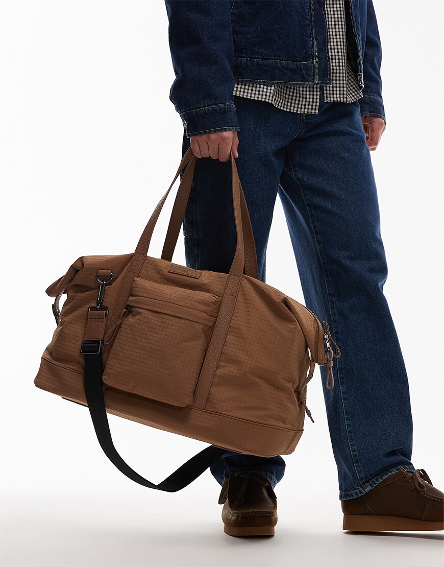 Man holding a brown duffel bag