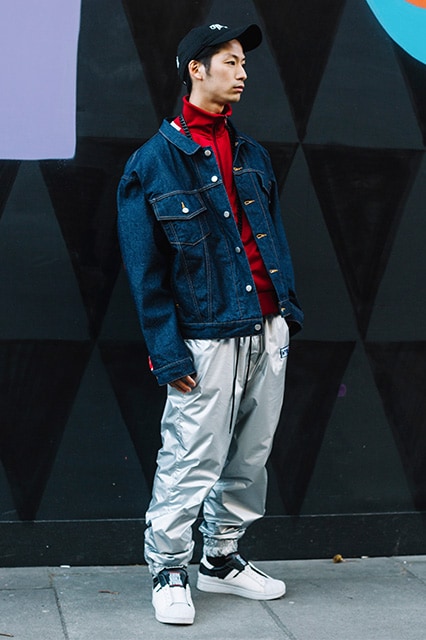 A street-styler wearing a half-zip jumper, denim jacket and metallic joggers | ASOS Style Feed