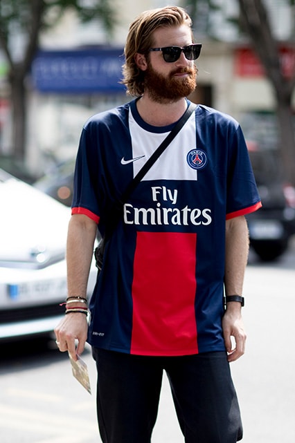 A street-styler wearing sunglasses, a football shirt and a cross-body bag | ASOS Style Feed