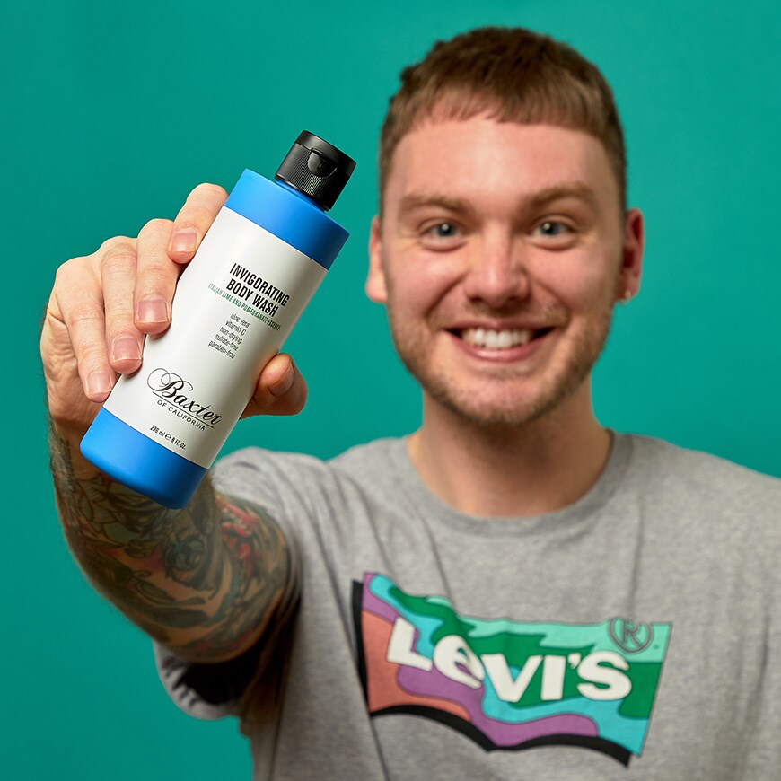 An ASOSer holding up a bottle of Baxter of California body wash | ASOS Style Feed