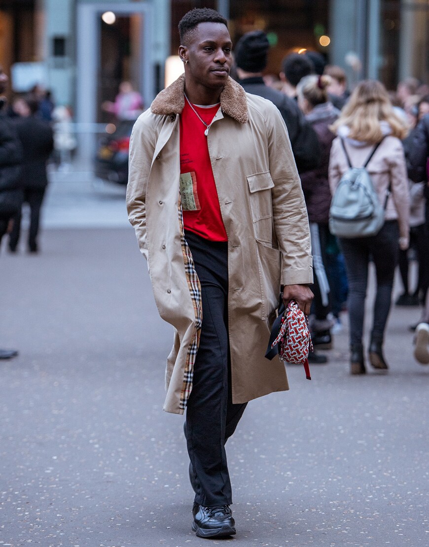 A picture of a street styler wearing a trench.
