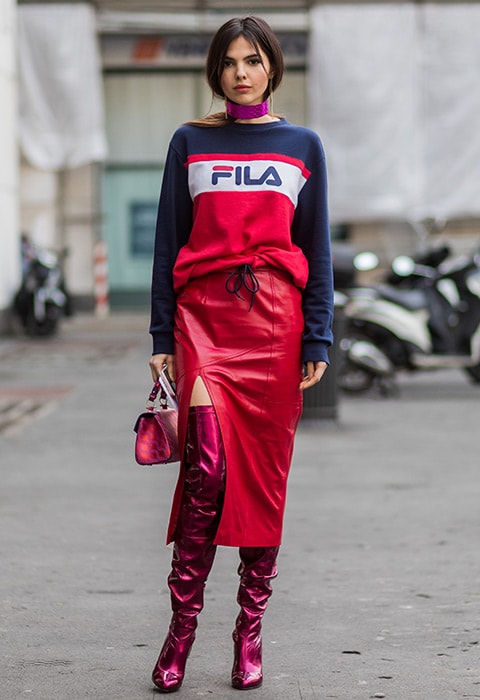 Doina Ciobanu wearing Vetements thigh-high satin boots with a slit leather skirt and a Fila top.