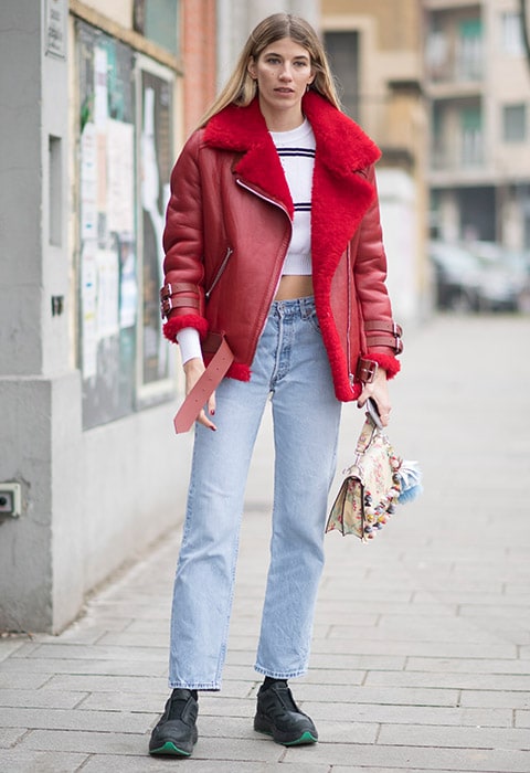 Veronika Heilbrunner wearing a red sheepskin Acne Studios jacket, denim jeans and crop top outside Fendi during Milan Fashion Week FW17 | ASOS Fashion & Beauty Feed