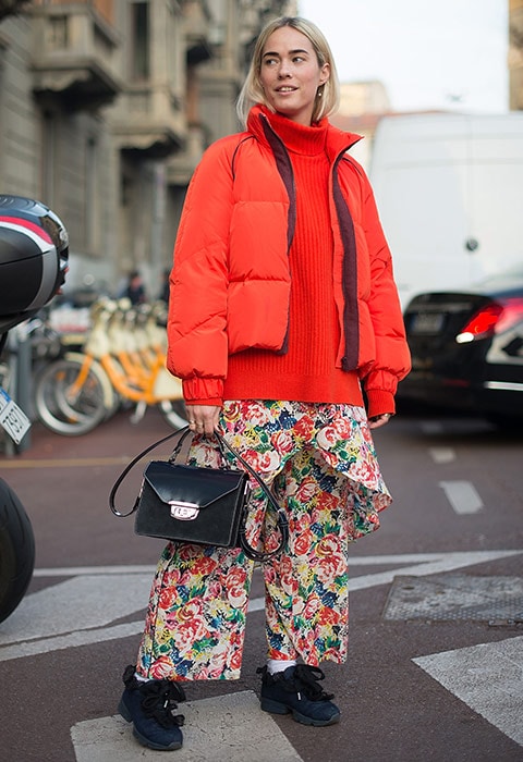 Blogger wearing floral wide-leg trousers and orange jumper and puffer Rihanna wearing black denim wide-leg trousers and jacket | ASOS Fashion & Beauty Feed