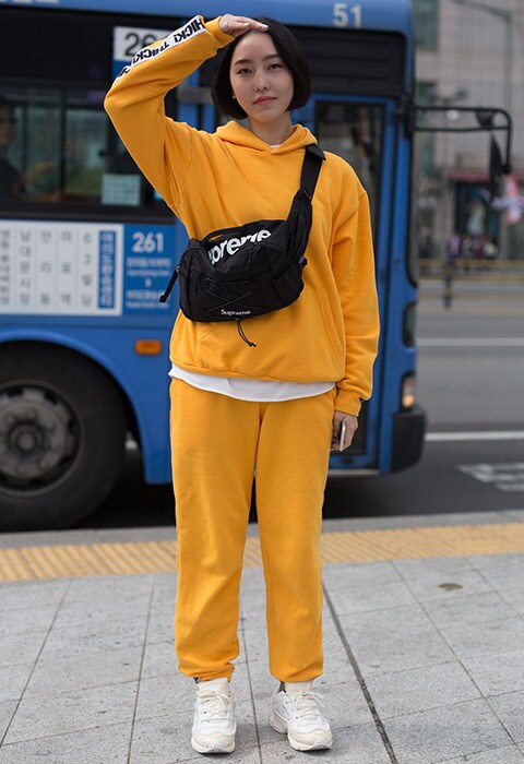 Blogger wearing a yellow tracksuit and Supreme bag | ASOS Fashion & Beauty Feed
