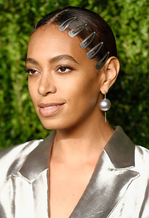 Solange Knowles wearing a metallic suit with silver hair clips.
