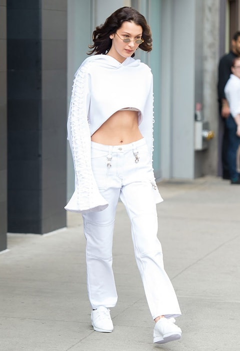 Bella Hadid wearing a white crop top and utility trousers | ASOS Fashion & Beauty Feed