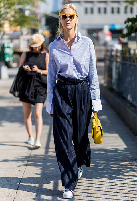 Linda Tol at NYFW wearing a striped shirt, oversized wide-leg trousers and trainers ith sunnies | ASOS Fashion and Beauty Feed