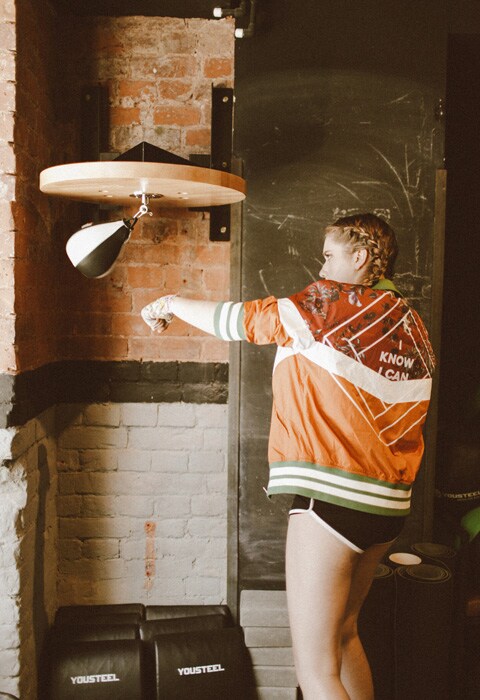 YouTube blogger Marie Novosad wearing an orange Nike tee while boxing | ASOS Fashion & Beauty Feed