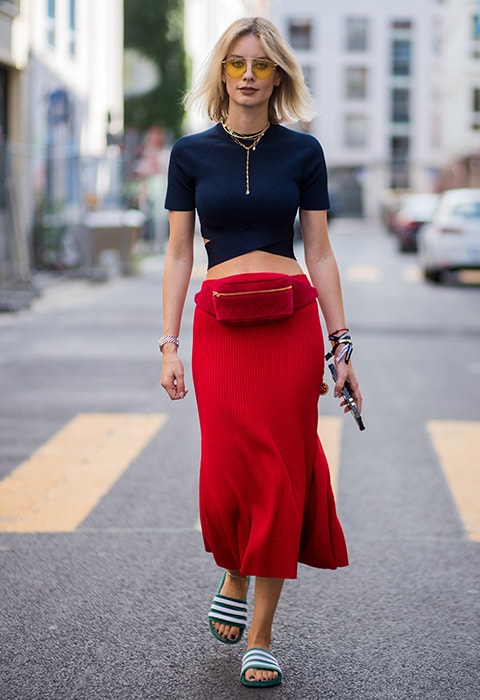 Blogger and street style star Lisa Hahnbueck wearing red bumbag with blue crop top, red midi skirt and adidas adilette sliders | ASOS Fashion and Beauty Feed