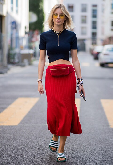 Blogger and street style star Lisa Hahnbueck wearing red bumbag with blue crop top, red midi skirt and adidas adilette sliders | ASOS Fashion and Beauty Feed