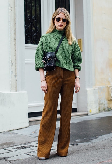 Street style star wearing a knit and wide-leg trousers