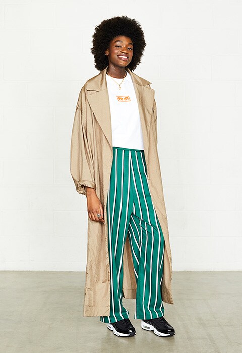 Model wearing green striped trousers and trench coat