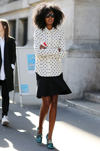 Street style star in polka dot shirt, skirt, shades and loafers