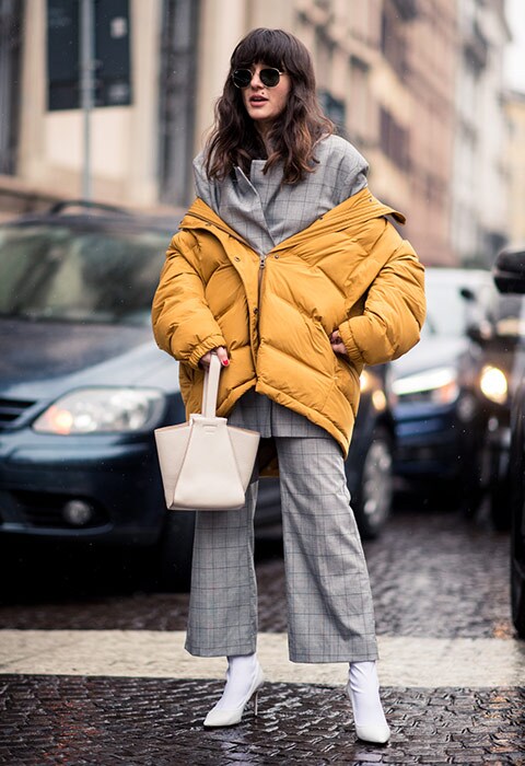 Street style star wearing a suit and puffer jacket