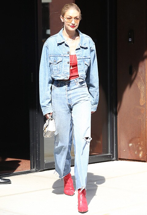 Gigi Hadid wearing denim jacket and jeans with boots
