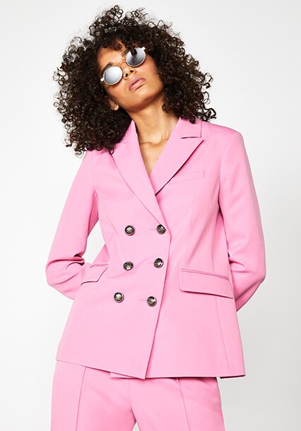 Model wearing a pink blazer with pink pants