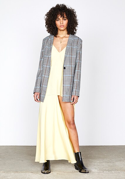 Model wearing a grey heritage check blazer with a yellow dress