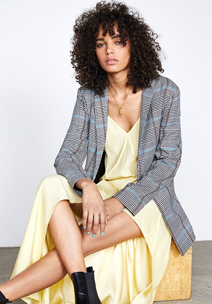 Model wearing a grey heritage check blazer with a yellow dress