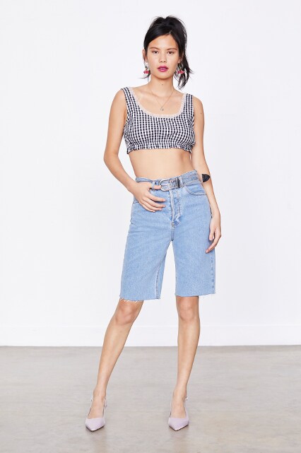 Model wearing a gingham top and denim cut-offs