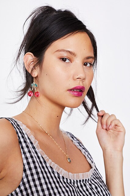 Model wearing a gingham bralet and cherry drop earrings