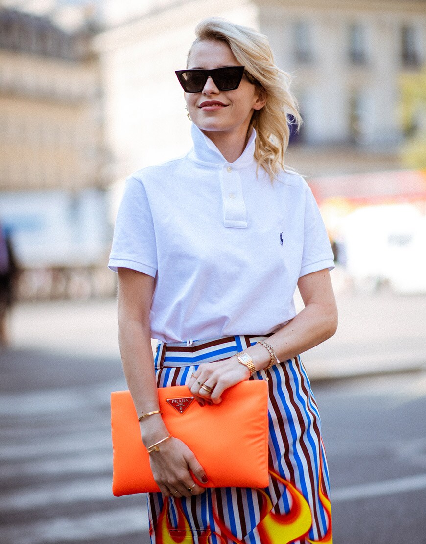 Orange prada clutch with white polo shirt at fashion week ASOS