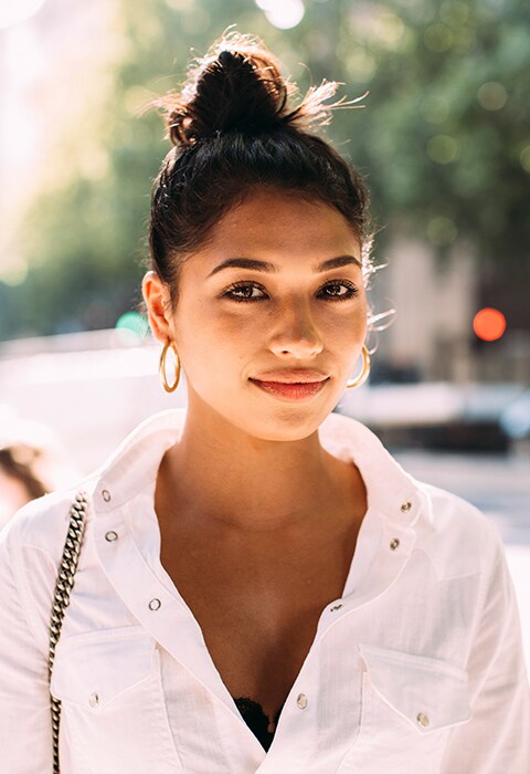 Look de street style de verano 2018 con moño y pendientes de aro dorado. El moño es el peinado de moda de este verano 2018. ASOS, lo último en moda y belleza.
