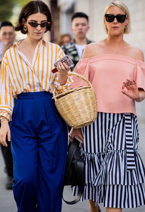 Look street style de inspiración Riviera francesa con bolso cesta de mimbre, falda de lino con estampado de rayas, y gafas de sol cat eye. Tendencias verano 2018.