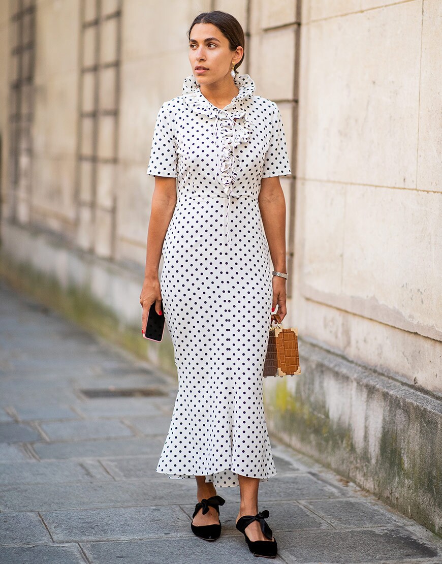 street style portant une robe mi-longue à pois durant la fashion week de paris SS18