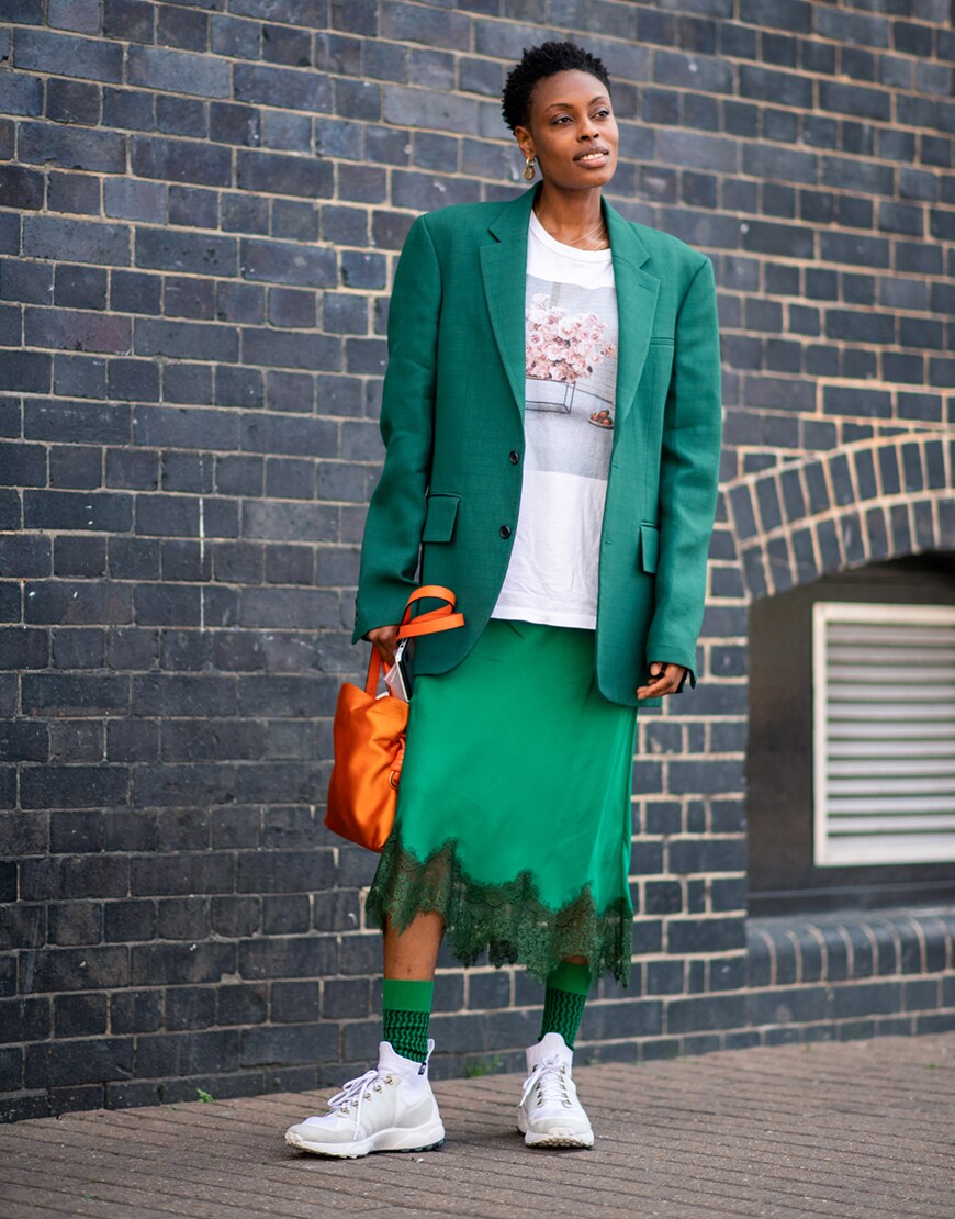 A street-styler wearing a T-shirt, blazer, skirt and trainers | ASOS Fashion & Beauty Feed